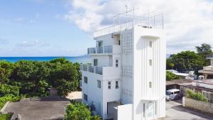 an apartment building with the ocean in the background at WITH SEA Nakama in Onna