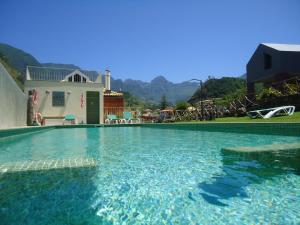 a swimming pool in front of a house at A Casa Estrelícia-Dourada Garcês in São Vicente