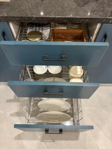 a drawer with white dishes in a kitchen at Chèrie Blueleaf in Jaipur