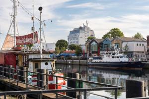a boat is docked at a marina with buildings at WIROtel Warnemünde in Warnemünde