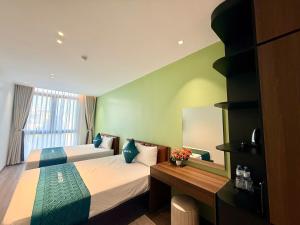 a hotel room with two beds and a mirror at Khách sạn XMen Thanh Hóa - Không gần biển in Thanh Hóa