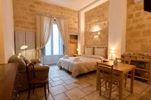 a bedroom with a bed and a table and a chair at Bed & Breakfast Casa Lopez in Barletta