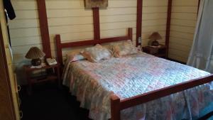 a bedroom with a bed with two nightstands and two lamps at El Repecho in Piriápolis