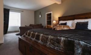 a cat sitting on a bed in a bedroom at The Newport Inn in Newport-On-Tay