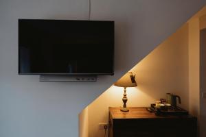 a flat screen tv hanging on a wall with a lamp at The Newport Inn in Newport-On-Tay