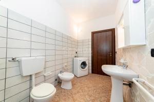 a bathroom with a toilet sink and a washing machine at Villa Mello in Torre Lapillo +21 photos