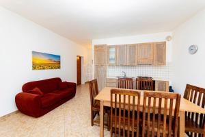 a living room with a red couch and a table at Villa Mello in Torre Lapillo