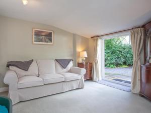 a living room with a white couch and a sliding glass door at Little Millhayes in Thorverton