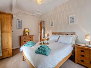 a bedroom with a bed with two towels on it at Bwthyn Hudol - Uk46711 in Pwllheli
