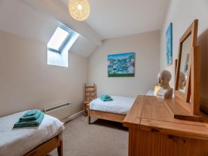 a bedroom with two beds and a desk and a window at Bwthyn Hudol - Uk46711 in Pwllheli +12 photos