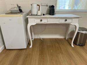 a white desk in a kitchen with a refrigerator at Beach House Studio in Busselton