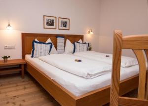 a bedroom with a large white bed with blue pillows at Lechnerhof in Braies