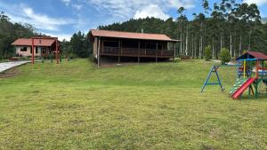 a playground with a house and a slide at Cabanas Vista da Pedra in Grão Pará