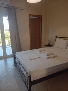 a bedroom with a bed with two towels on it at Eva's apartments in Nafpaktos