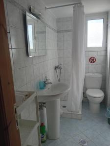a white bathroom with a toilet and a sink at Eva's apartments in Nafpaktos +14 photos