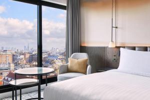 a hotel room with a bed and a chair and a window at London Marriott Hotel Marble Arch in London