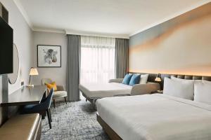 a hotel room with two beds and a couch at London Marriott Hotel Marble Arch in London +27 photos