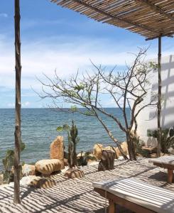 a view of the ocean from a beach with a bench at 3B MAISON Homestay & Villa in Mui Ne