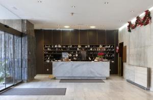 a restaurant lobby with a counter with wine bottles at Apartamentos Centro Colón in Madrid