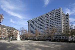 a large building with a statue in front of it at Apartamentos Centro Colón in Madrid