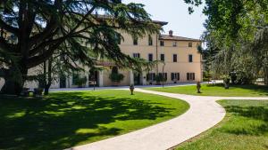 a walkway in front of a building in a park at Posta Donini 1579 - UNA Esperienze in San Martino in Campo