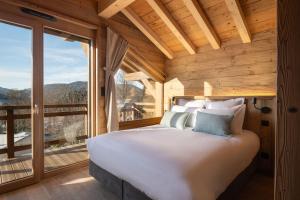 a bedroom with a large bed and a large window at Sorelle Chalet, spa, indoor pool, lake view in Gérardmer +34 photos