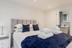 a bedroom with a white bed with towels on it at Aurora South - Short Walk to Ashley Cross in Poole