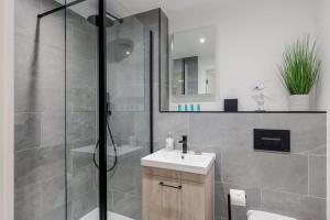 a bathroom with a shower and a toilet and a sink at Aurora South - Short Walk to Ashley Cross in Poole