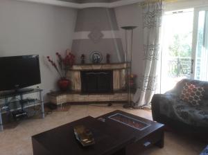 a living room with a couch and a fireplace at Villa Natalia in Kouramádes
