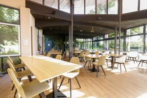 a restaurant with tables and chairs and windows at Logis Hôtel Le Keréden in Locarn