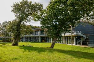 a building with two trees in front of it at Logis Hôtel Le Keréden in Locarn
