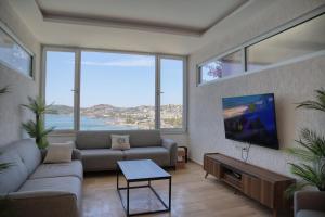 a living room with a couch and a tv at Hotel Gumbet in Bodrum City