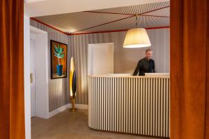 a man standing at a counter in a room at Almarine Eiffel Hotel & Spa by Malone in Paris