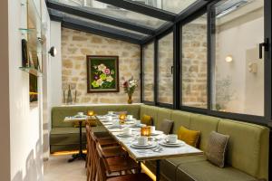 a dining room with tables and chairs and windows at Almarine Eiffel Hotel & Spa by Malone in Paris