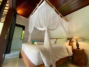 a bedroom with a white bed with a canopy at Ubud jungle House behind bintang supermarket ubud in Ubud +160 photos