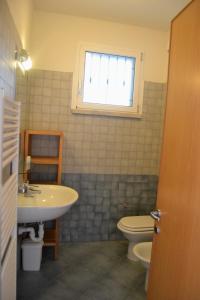 a bathroom with a sink and a toilet and a window at Etruriamare in San Vincenzo