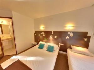 ein Hotelzimmer mit zwei Betten und einem Spiegel in der Unterkunft The Originals Access, Hôtel Béziers Est in Béziers