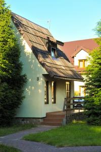una pequeña casa con techo de metal y escaleras en Stary Młyn, en Bolesławiec