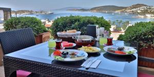 a table with plates of food on top of a balcony at Hotel Gumbet in Bodrum City