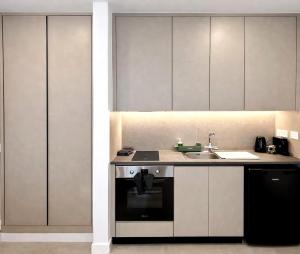 a kitchen with a sink and a stove at White Arches Studio Suite by TrulyCyprus in Limassol