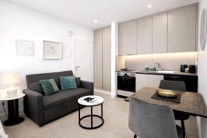 a living room with a couch and a table at White Arches Studio Suite by TrulyCyprus in Limassol +4 photos