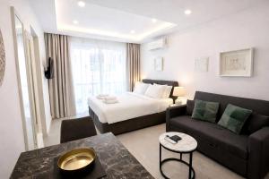 a hotel room with a bed and a couch at White Arches Studio Suite by TrulyCyprus in Limassol