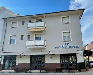 a hotel with tables in front of it at Piccolo Hotel in Rosignano Solvay