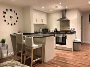 cocina con encimera, sillas y reloj en Loft Living Oxford, en Oxford