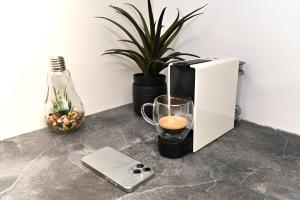 a coffee maker sitting on a counter with a drink in a glass at Cortina Nord Panoramic Studio in Voluntari