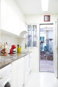 a kitchen with white cabinets and a large glass door at Espectacular chalet para descansar in Torrent