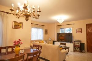 a living room with a chandelier and a dining room at Espectacular chalet para descansar in Torrent