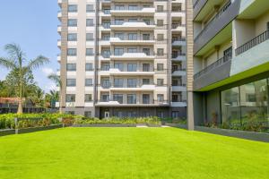 a large green lawn in front of a building at The Bantree by Clifton Homes in Accra