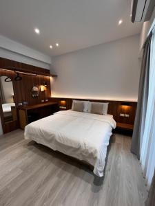 a bedroom with a large bed with white sheets at Zao Orange Homestay in Taitung City