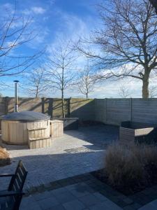 a patio with a fire pit and a fence at De Notelaar in Alveringem